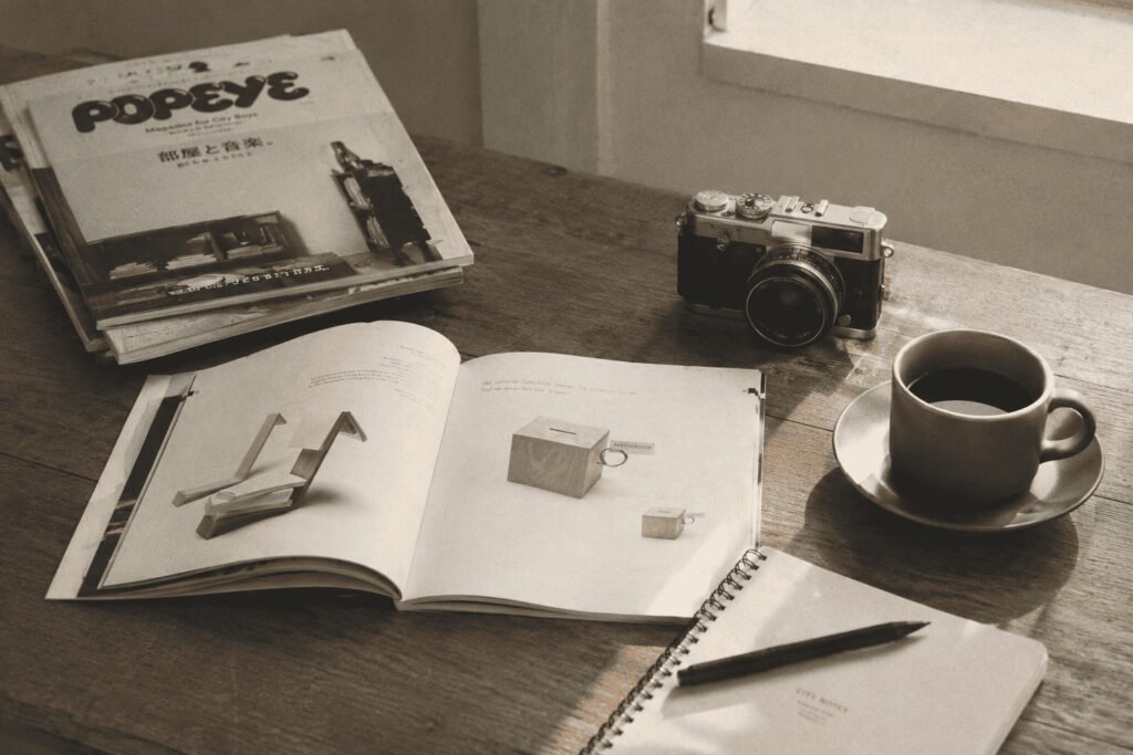Revista de OFFLINE CLUB acompañada de una taza de café y objetos de trabajo sobre un escritorio.